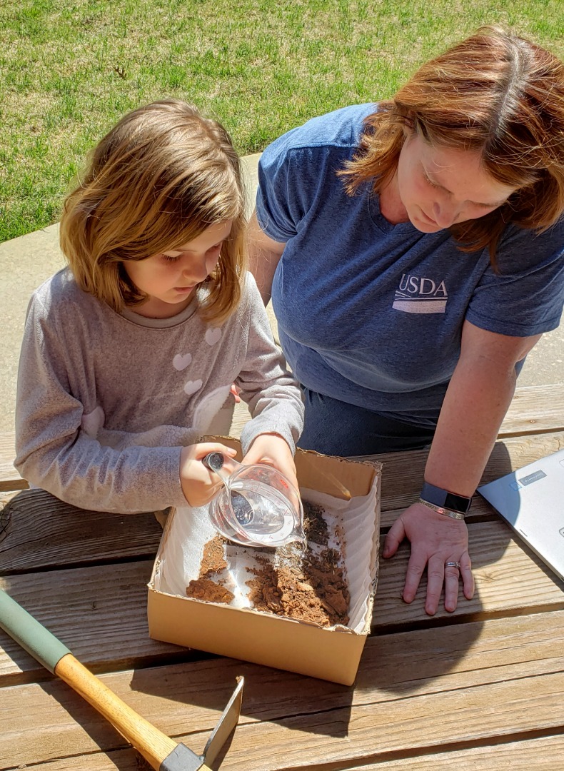 An ARS employee working with a child on an at-home experiment